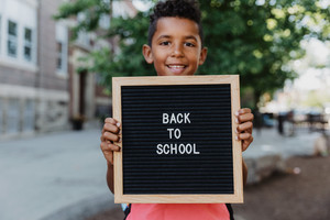 Boy holds sign  - First Day of School